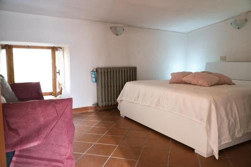 a bedroom with a white bed and a window at Un Passo dal Cielo...Apartment in San Potito