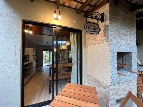 a door to a restaurant with a table and a fireplace at Pousada Flor de Lotus in Praia do Rosa