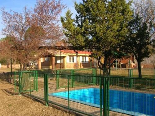 een hek rond een zwembad voor een huis bij Casa de Campo en Nono in Nono