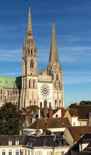 una grande cattedrale con due torri e una città di Résidence Services Séniors MONTANA CHARTRES a Chartres