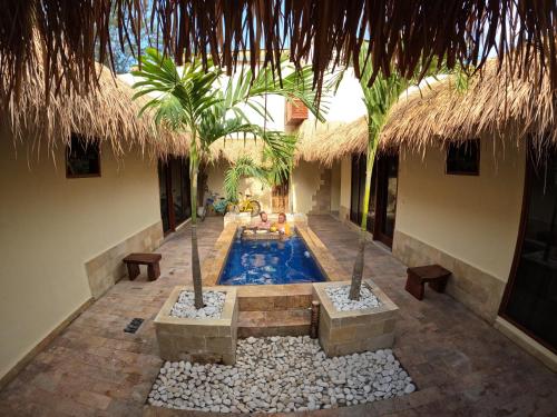 een zwembad in het midden van een resort met palmbomen bij La Bella - Hotel Villa & Spa in Gili Trawangan