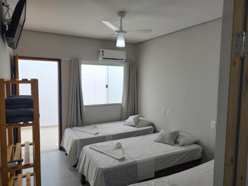 a room with two beds and a window at Hotel Veleiro in São Sebastião