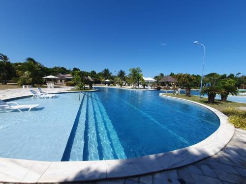 a pool at a resort with blue water at Cobertura 3Q ILOA Barra de S Miguel Castelo B Temporada in Barra de São Miguel
