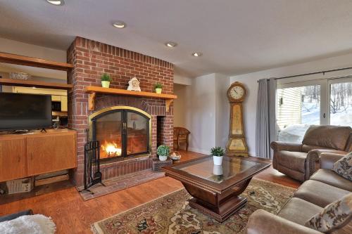 a living room with a fireplace and a couch at Skiers! Fox Hollow 2BR 2BA Condo, Across from Pico, Minutes to Killington condo in Mendon