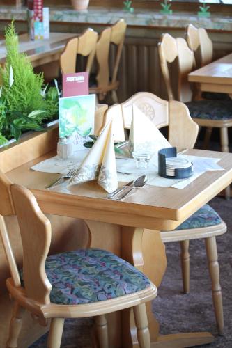 a wooden table with chairs and a tableasteryasteryasteryasteryasteryasteryasteryastery at Waldhotel Dornröschenshöh in Hemfurth-Edersee