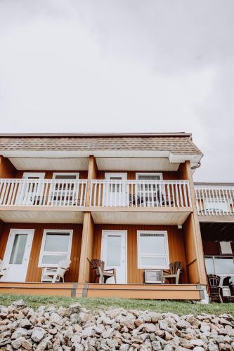 a house with a balcony and chairs on it at La Place Rendez-Vous Hotel in Fort Frances