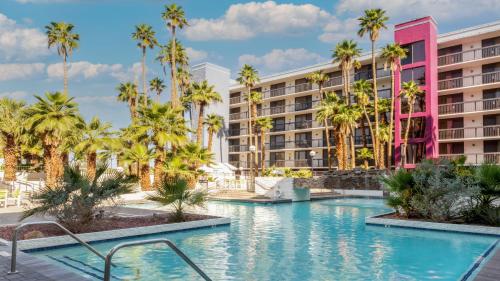 een zwembad met palmbomen voor een hotel bij Holiday Inn & Suites Phoenix-Mesa-Chandler, an IHG Hotel in Mesa