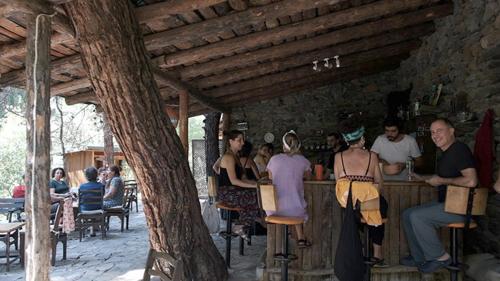 un grupo de personas sentadas en un bar en un edificio en zerguz camping, 
