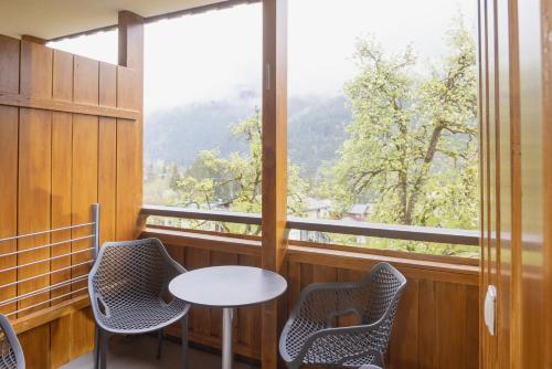 a room with a table and chairs and a large window at Apartmenthaus Matri by Pferd auf Wolke in Wald am Arlberg
