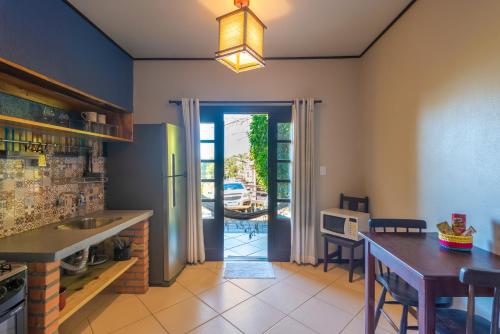 a kitchen with a table and a dining room at Pousada Flor de Lotus in Praia do Rosa