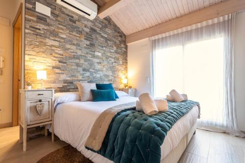 1 dormitorio con 1 cama grande y pared de piedra en Casa 20 minutos de Barcelona y WIFI alta capacidad en Sant Cugat del Vallès