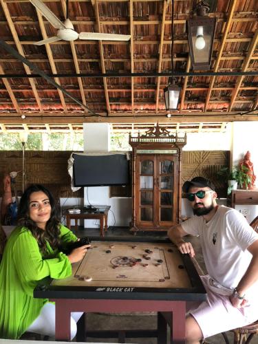 a man and a woman sitting at a table at Vala House in Cherai Beach