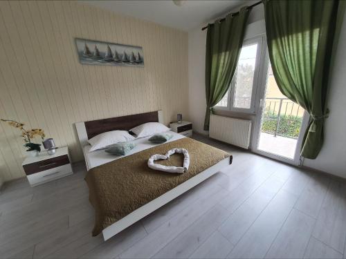 um quarto com uma cama grande e uma decoração de coração em Family friendly apartments with a swimming pool Kastel Novi, Kastela - 18645 em Kaštela
