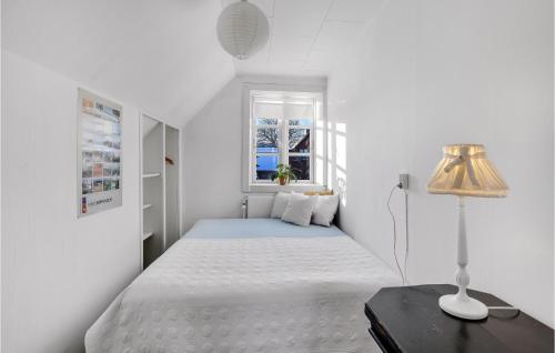 a white bedroom with a bed and a window at Amazing Home In stermarie With 3 Bedrooms And Wifi in Østermarie