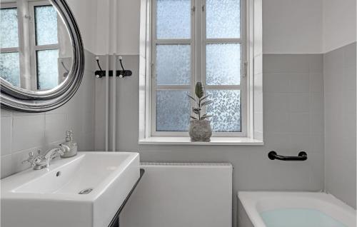 a white bathroom with a sink and a mirror at Amazing Home In stermarie With 3 Bedrooms And Wifi in Østermarie