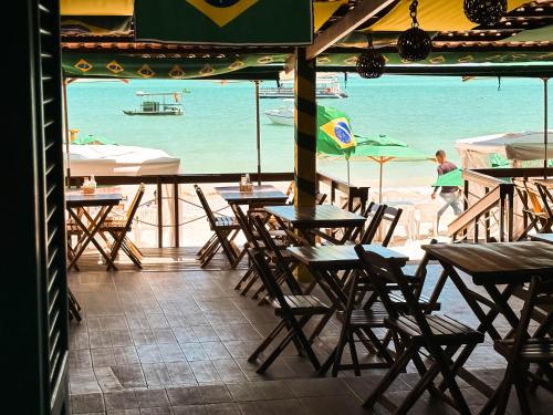 a restaurant with tables and chairs and a view of the ocean at Beach Point Barra Grande in Maragogi