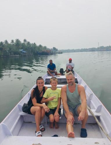 a family sitting in a boat on the water at Vala House - Full Villa in Pallipuram