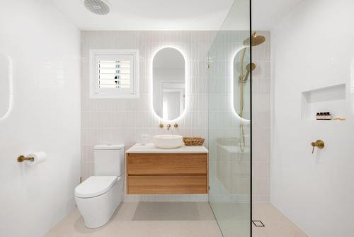 a bathroom with a toilet and a sink and a mirror at Serenity by the Sea in Scarborough