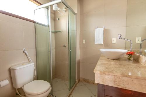 y baño con aseo, lavabo y ducha. en Flat Térreo Brisas do Amor 2 Dormitorios, en Pipa