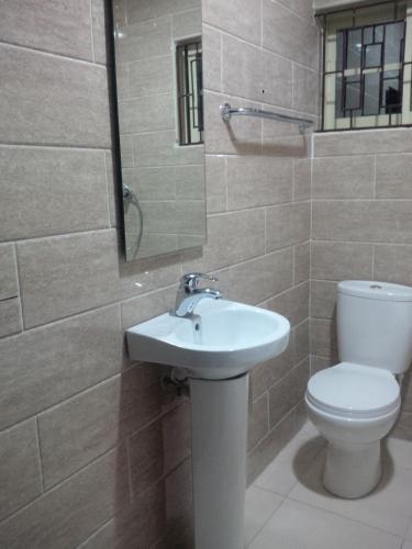 a bathroom with a toilet and a sink at Haute Aparthotel in Ikeja