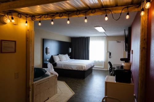 a hotel room with a bed and a living room at Envi Boutique Hotel Henderson-Evansville South in Henderson