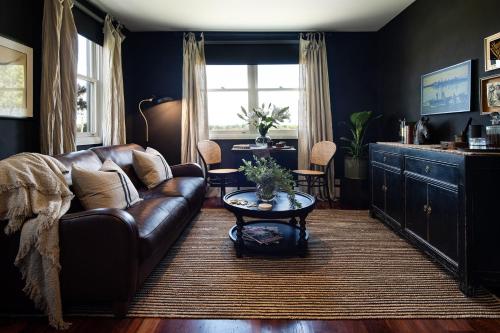 a living room with a leather couch and a table at The Nook in Daylesford