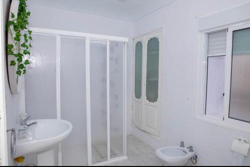 ein weißes Bad mit einem Waschbecken und einem WC in der Unterkunft Apartamento deluxe Terraza y bbq in Santa Amalia