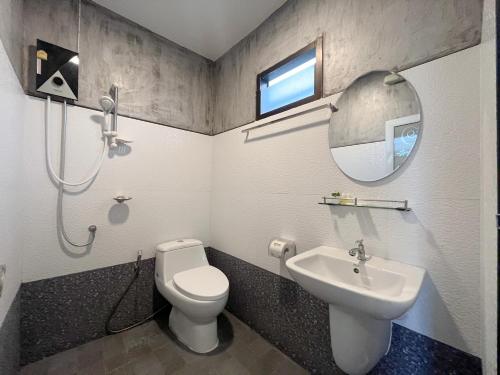 een badkamer met een toilet, een wastafel en een spiegel bij บวกบัววิวรีสอทร์ in Nan
