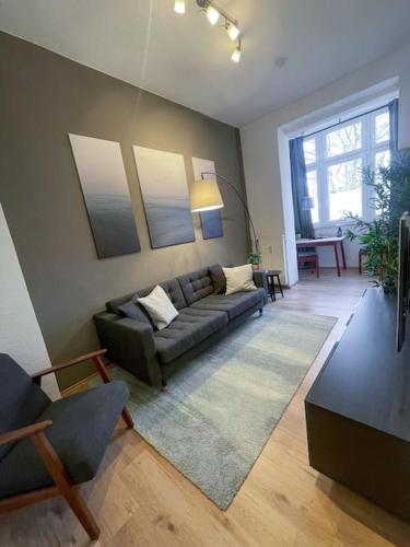 un salon avec un canapé et une table dans l'établissement Modern Cozy apt. -with 2 TV, Netflix and work desk, à Essen