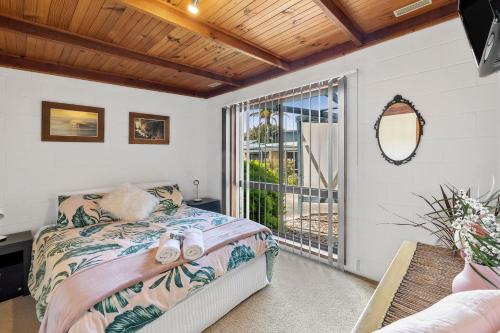a bedroom with a bed and a balcony at Magic on Murray in Anglesea