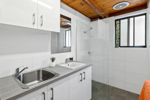 a white kitchen with a sink and a window at Magic on Murray in Anglesea