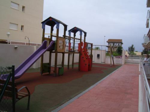 a playground on the side of a building with a slide at Apartamentos Playa de Moncofa in Moncófar