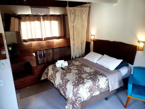 a bedroom with a bed and a window at Pousada Rosa Maria in Praia do Rosa