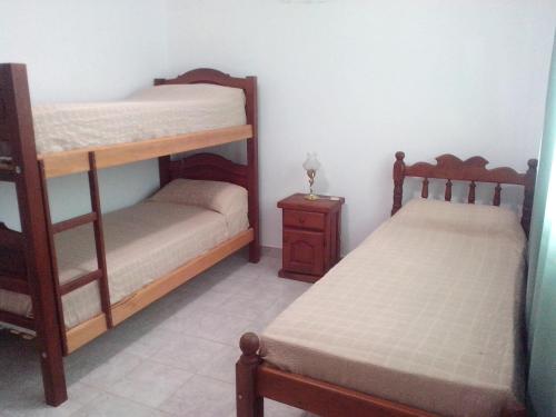 a bedroom with two bunk beds and a night stand at Sierras de los Nietos in Potrero de los Funes