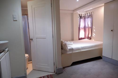 a small bedroom with a bed and a window at Sunset View Ridge Residences in Baguio