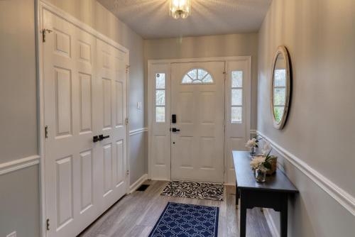 un pasillo con una puerta blanca y una mesa en The Basye House - Secluded Mountain Valley Getaway en Basye