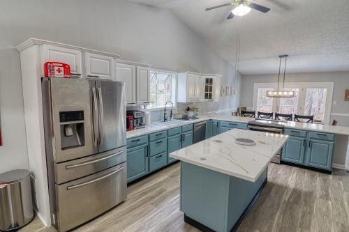 a kitchen with blue cabinets and a stainless steel refrigerator at The Basye House - Secluded Mountain Valley Getaway in Basye