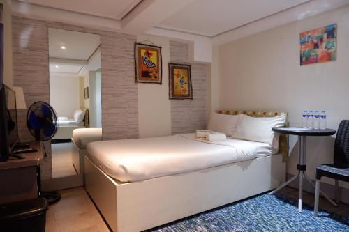 um quarto com uma grande cama branca num quarto em Sunset View Ridge Residences em Baguio