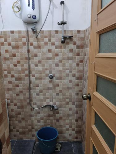 a bathroom with a shower with a bucket in it at Keneth Hostel 