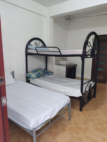 a room with two bunk beds in a room at Keneth Hostel 