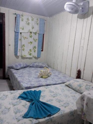 two beds in a room with blue sheets at Pousada Praia Mansa Superagui in Superagui