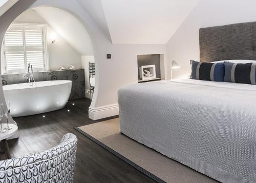 una camera con un grande letto e una vasca da bagno di Brocco On The Park Boutique Hotel a Sheffield