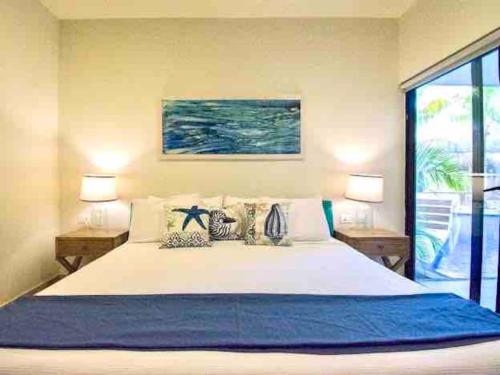 1 dormitorio con 1 cama blanca grande y 2 lámparas en CRlSTALIDA Swim up & free bikes by Casa Paraiso en Tulum