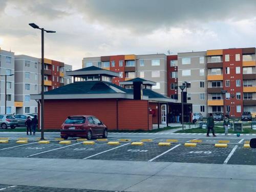 a car parked in a parking lot next to a building at Dpto Condominio Alto Lomas Del Carmen in Temuco
