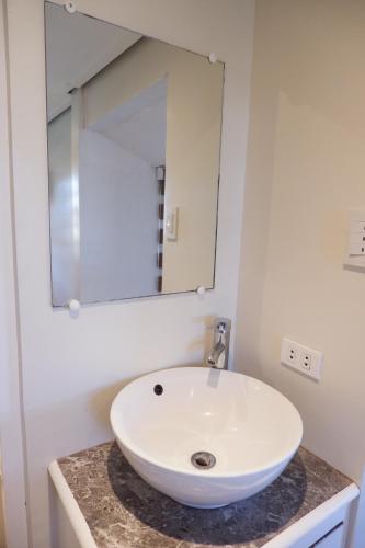 a bathroom with a white sink and a mirror at Sunset View Ridge Residences in Baguio
