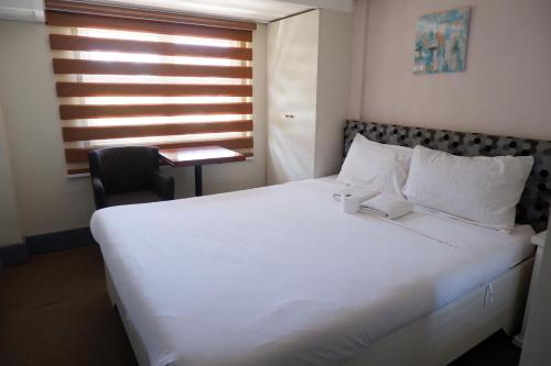a large white bed in a room with a window at Sunset View Ridge Residences in Baguio