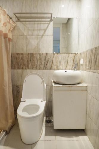 a bathroom with a toilet and a sink and a mirror at Sunset View Ridge Residences in Baguio