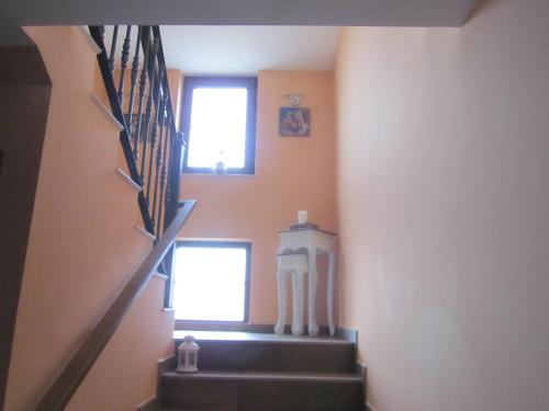 a stairway with two windows and a statue in a room at La Posada de Toribia in Val de San Lorenzo