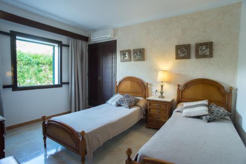 a bedroom with two beds and a window at Villa Dos Pinos in Cala d´Or