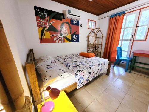 a bedroom with a bed and a table and a desk at Divanga Hostel and Diving in Taganga